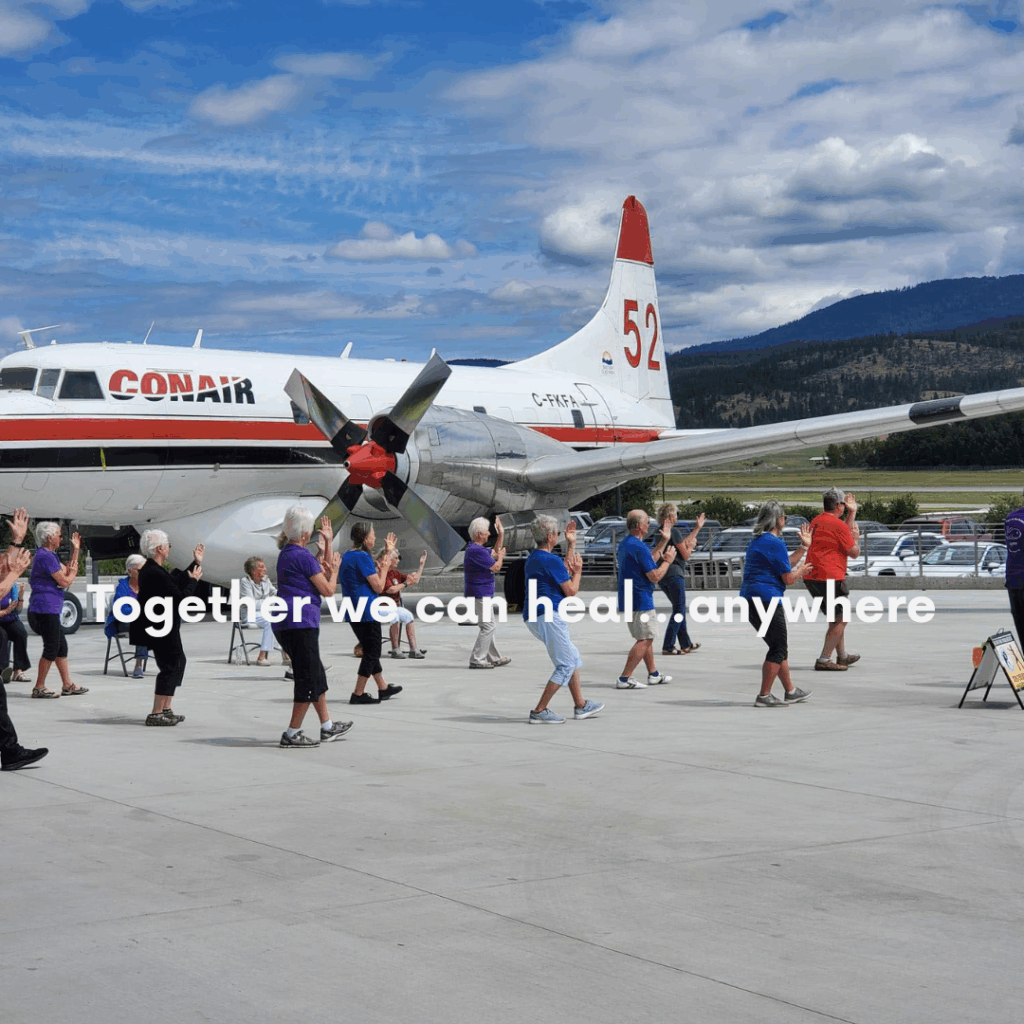 Group of Tai Chi'ers on a tarmac beside a jet plane