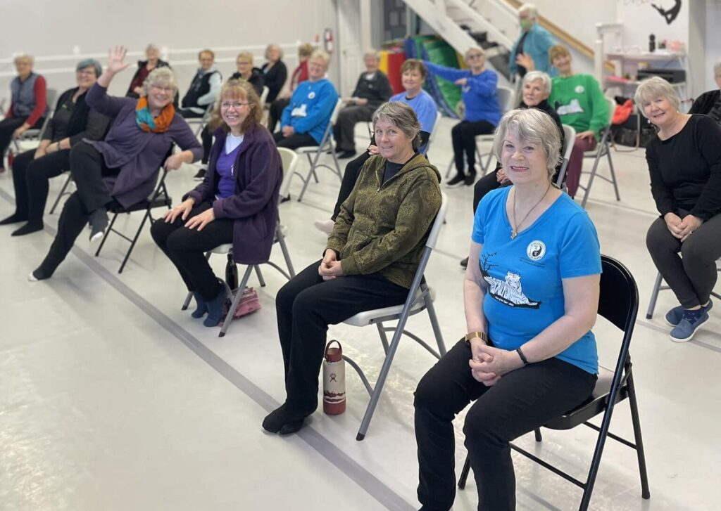Seated Tai Chi class, three rows of people